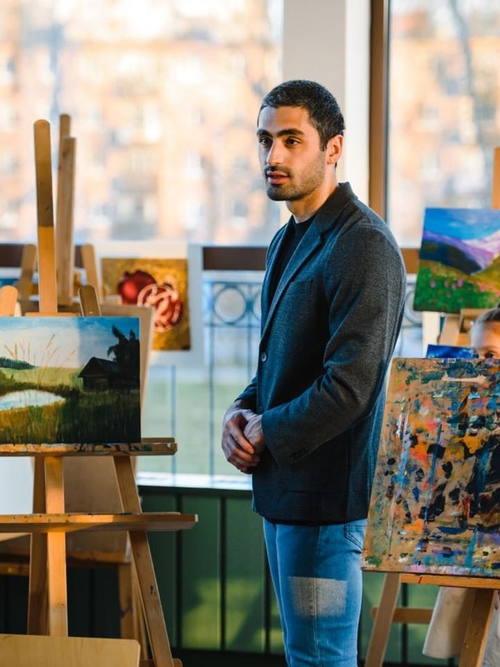 An art mentor reviewing work on the easels